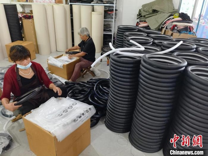 圖為村民在汽車飾品企業(yè)生產(chǎn)車間中工作?！巫雍?攝