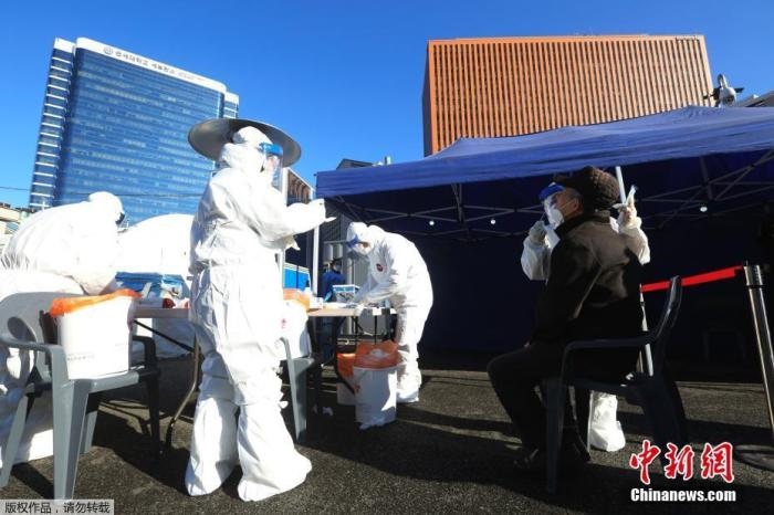 資料圖：韓國(guó)首爾，醫(yī)務(wù)人員對(duì)市民進(jìn)行新冠病毒檢測(cè)。