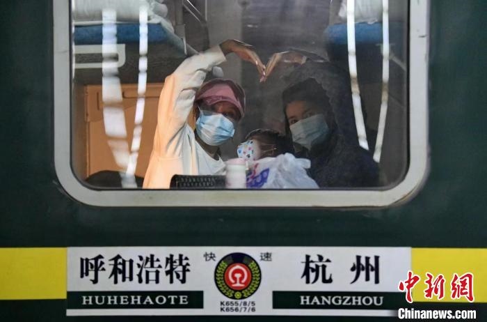 圖為登上轉(zhuǎn)運火車的游客向額濟(jì)納比心?！⊥趵?攝