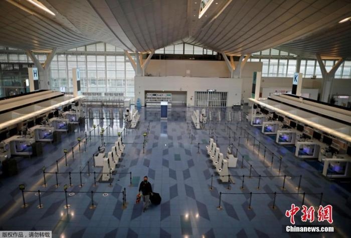 資料圖：日本東京，東京國(guó)際機(jī)場(chǎng)，一名乘客在國(guó)際航班航站樓的登機(jī)區(qū)。