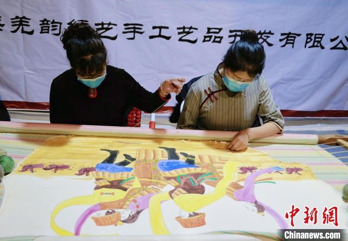 圖為皮繡藝人在市集上“秀”指尖技藝?！●R銘言 攝