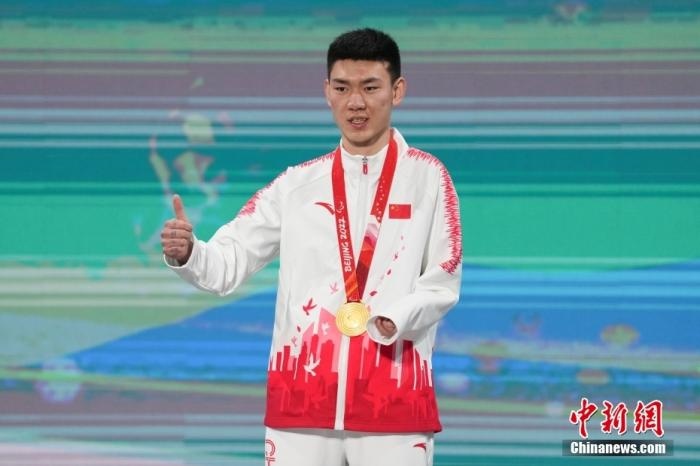 3月6日，梁景怡在延慶頒獎(jiǎng)廣場(chǎng)領(lǐng)獎(jiǎng)臺(tái)上豎起大拇指。當(dāng)日，在國(guó)家高山滑雪中心舉行的北京2022年冬殘奧會(huì)殘奧高山滑雪男子超級(jí)大回轉(zhuǎn)—站姿決賽中，中國(guó)選手梁景怡奪得冠軍。 <a target='_blank' href='/'>中新社</a>記者 楊華峰 攝