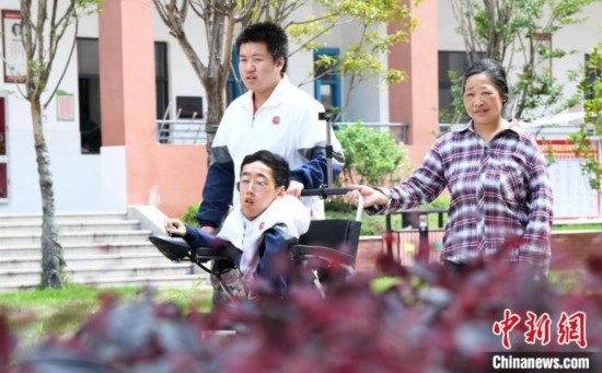 碰上天氣好，朱金祥就會利用休息時間，和鐘華強母親將其推出來賞賞花，曬曬太陽，呼吸一下外面的新鮮空氣。 卓忠偉 攝