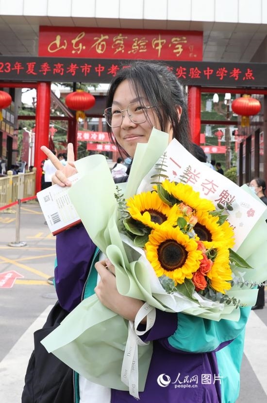 6月7日高考首日，山東67萬考生走進(jìn)考場，拼搏逐夢。在山東省實(shí)驗(yàn)中學(xué)考點(diǎn)，考生進(jìn)考場前手捧向日葵花拍照留念，寓意“一舉奪魁”。人民網(wǎng)記者 劉祺攝