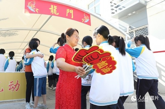6月7日一早，雄安新區(qū)安新中學(xué)老師在給同學(xué)們加油鼓勁兒。人民網(wǎng) 李兆民攝