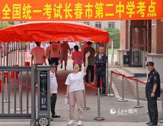 6月7日，在長春市第二中學(xué)考點(diǎn)，一名考生信心滿滿進(jìn)入考場，并與家長揮手致意。人民網(wǎng)記者 李洋攝