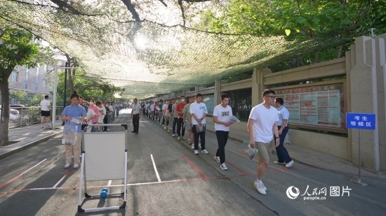 6月7日，烏魯木齊市第七十中學(xué)門口，考生們有序進(jìn)入考場。人民網(wǎng) 李欣洋攝