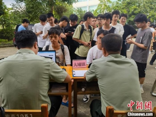 專武干部在發(fā)放兵役登記證。韋碩 攝