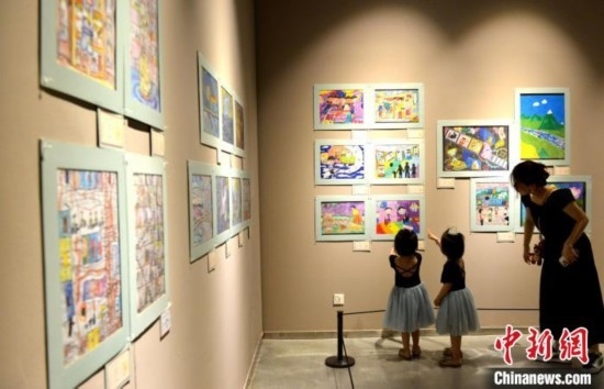 圖為家長帶著孩子參觀展覽。呂明 攝