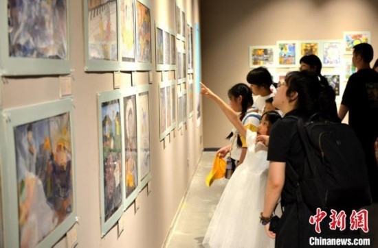 圖為家長帶著孩子參觀展覽。呂明 攝