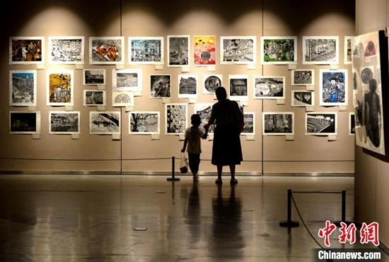 圖為家長帶著孩子參觀展覽。呂明 攝