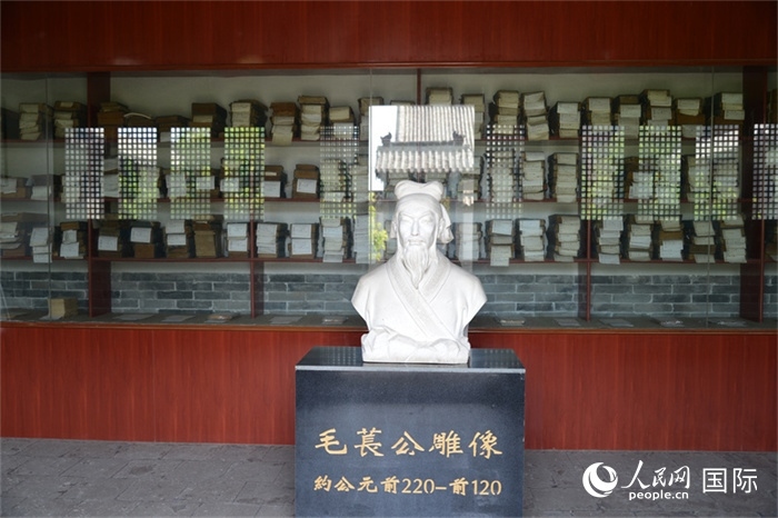 河間詩經(jīng)齋毛萇雕像。雕像后書櫥中陳列的是歷代各版本《詩經(jīng)》及譯本。 人民網(wǎng) 趙昭攝