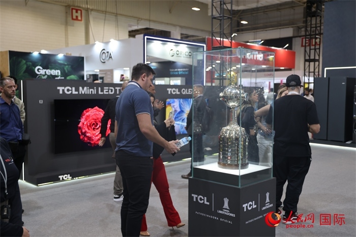 參觀者在TCL展臺前觀看南美解放者杯獎杯，據(jù)介紹，TCL是南美解放者杯（2023—2026賽季）全球官方合作伙伴。（人民網(wǎng)記者 時元皓攝）