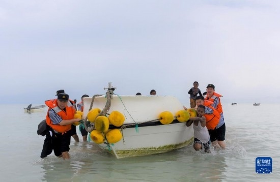7月21日，中國海軍“和平方舟”號(hào)醫(yī)院船醫(yī)護(hù)人員涉水登島，前往基里巴斯一診療點(diǎn)。新華社記者 黎云 攝