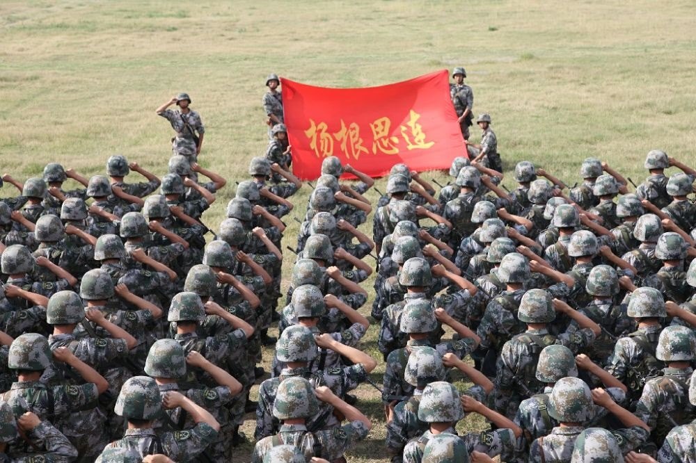 ↑“楊根思連”官兵執(zhí)行任務(wù)前向連旗宣誓（資料照片）。新華社發(fā)