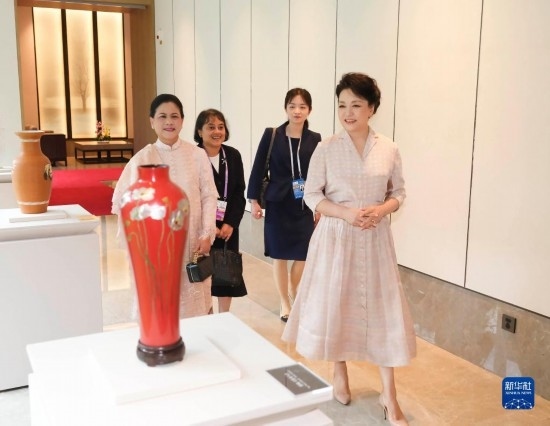 7月27日下午，國家主席習(xí)近平夫人彭麗媛在四川成都會(huì)見陪同印度尼西亞總統(tǒng)佐科來華出席第31屆世界大學(xué)生夏季運(yùn)動(dòng)會(huì)開幕式并訪華的總統(tǒng)夫人伊莉亞娜。這是彭麗媛和伊莉亞娜欣賞成都特色非遺工藝品。新華社記者 丁林 攝