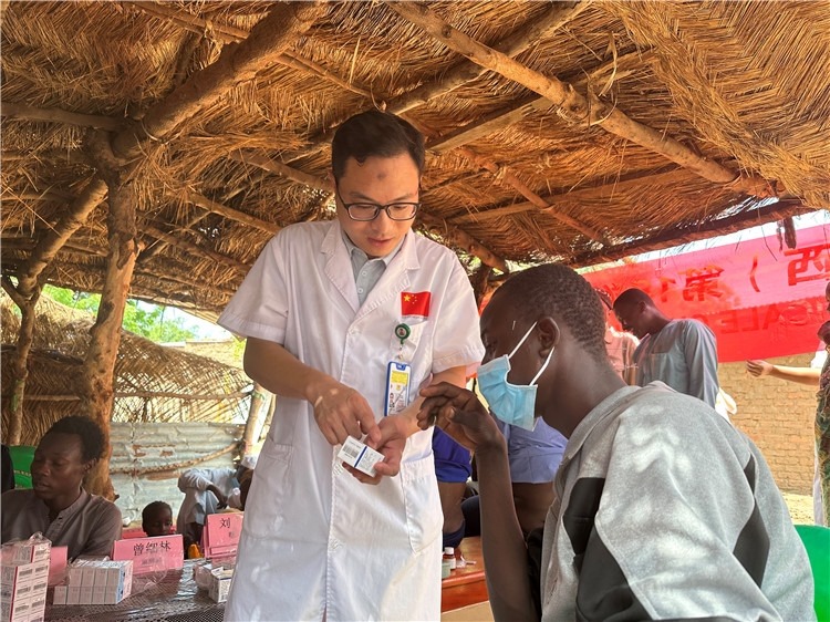 圖為南昌大學(xué)第一附屬醫(yī)院病理科主治醫(yī)師張振東為村民解說(shuō)藥品使用方法。中國(guó)駐乍得醫(yī)療隊(duì)供圖