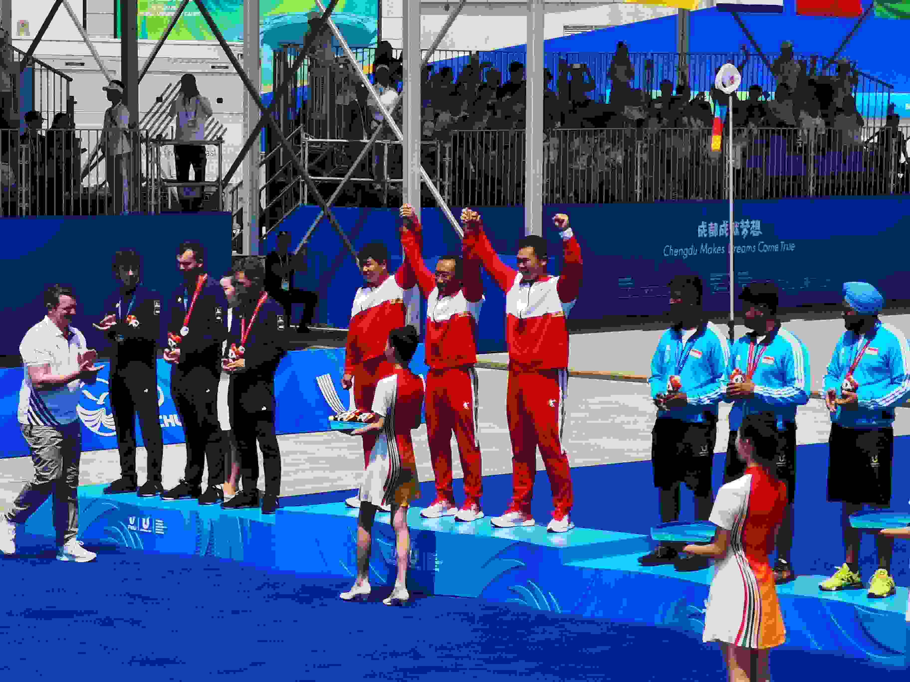 7月30日，在成都大運會男子復(fù)合弓團體頒獎儀式中，中國隊?wèi)c祝奪得冠軍。 人民網(wǎng)記者 楊磊攝