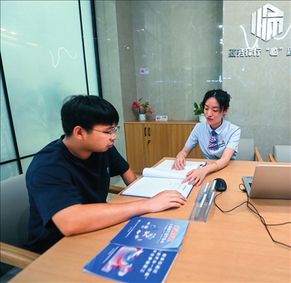 在杭州市臨安區(qū)政務服務中心的“為企服務中心”，黨員志愿者（右）解答企業(yè)主的疑問（2023年7月7日攝）。徐昱攝/本刊