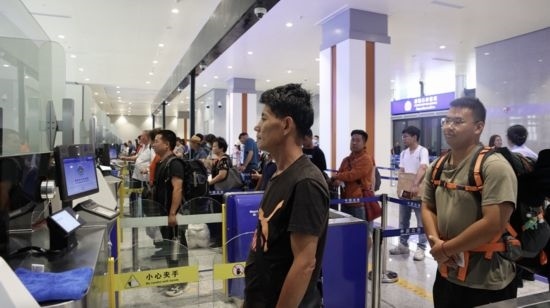 6月13日，乘坐中老鐵路國(guó)際旅客列車的旅客在磨憨邊檢大廳排隊(duì)候檢。李揚(yáng) 攝