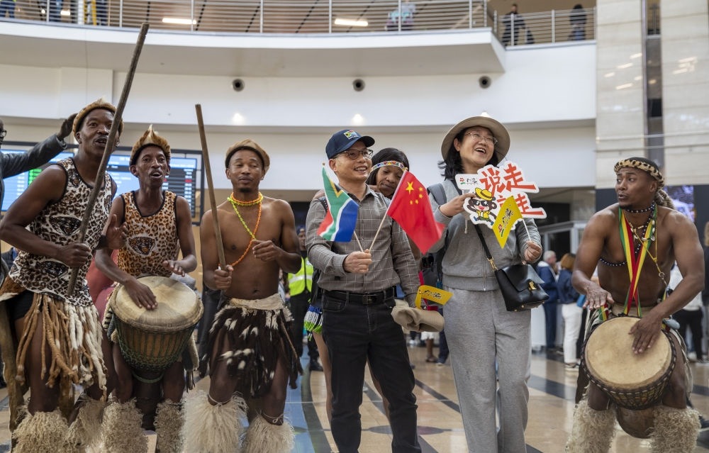 在南非約翰內(nèi)斯堡坦博國際機(jī)場，南非舞蹈演員歡迎中國試點(diǎn)恢復(fù)出境團(tuán)隊(duì)旅游后首批抵達(dá)南非的中國游客（2023年3月29日攝）。