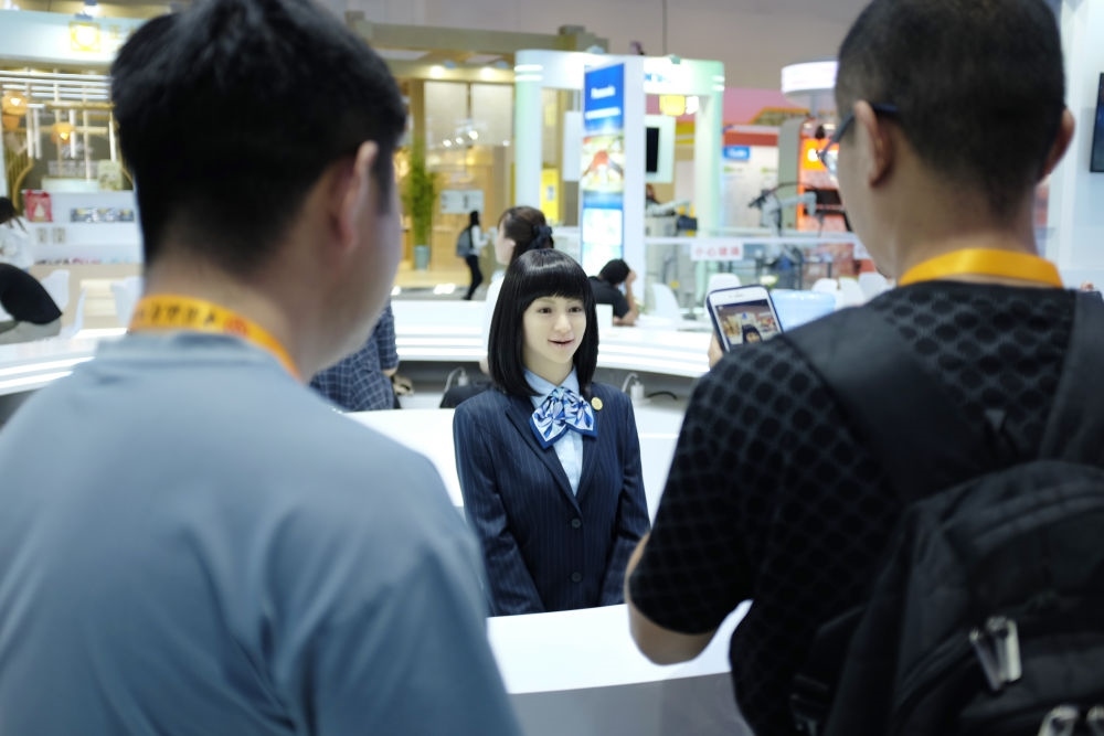 9月1日，媒體記者在國家會議中心與服務(wù)機器人互動。新華社記者 劉夢琪 攝