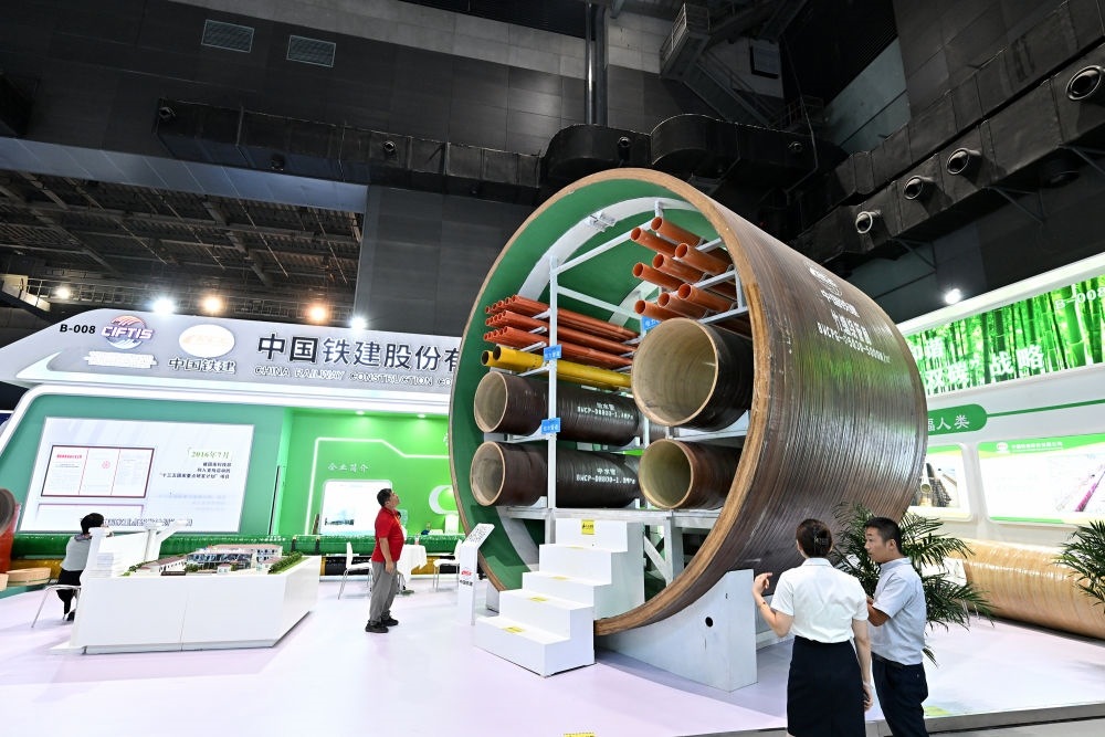 9月2日，在國家體育館舉行的服貿(mào)會(huì)環(huán)境服務(wù)專題展上，客商在中國鐵建展位竹纏繞管廊旁了解信息。新華社記者 李鑫 攝