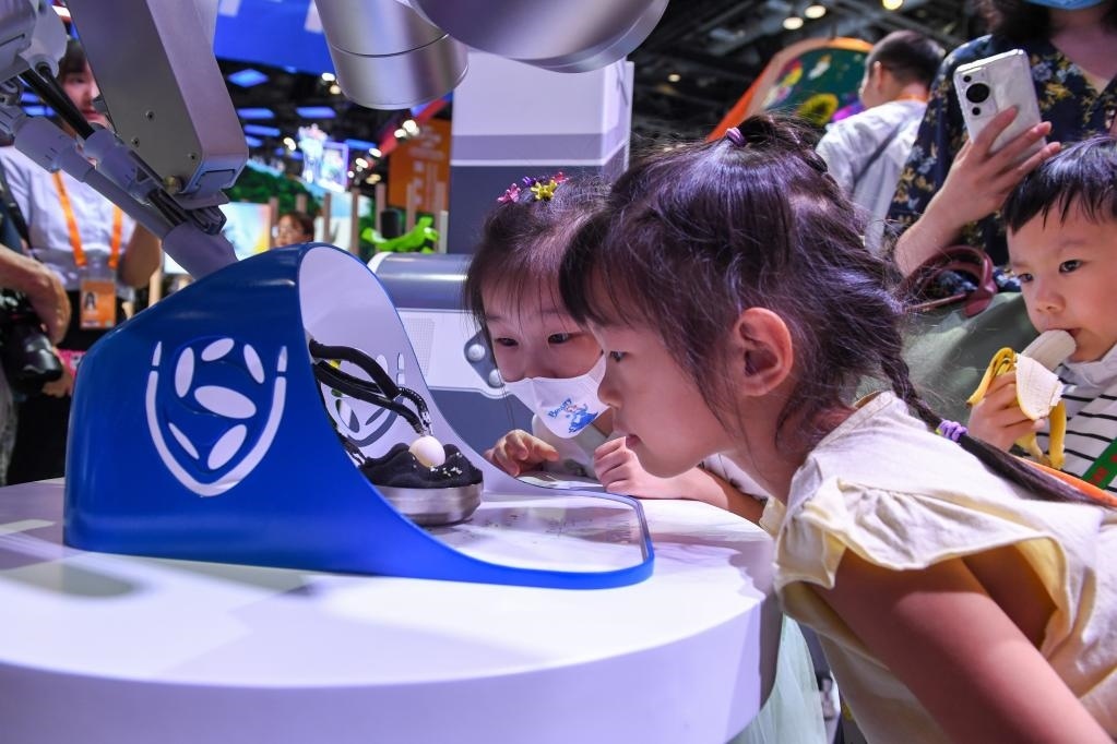 9月3日，幾名小朋友在國(guó)家會(huì)議中心觀看單孔腔鏡手術(shù)機(jī)器人展示。新華社記者 鞠煥宗 攝