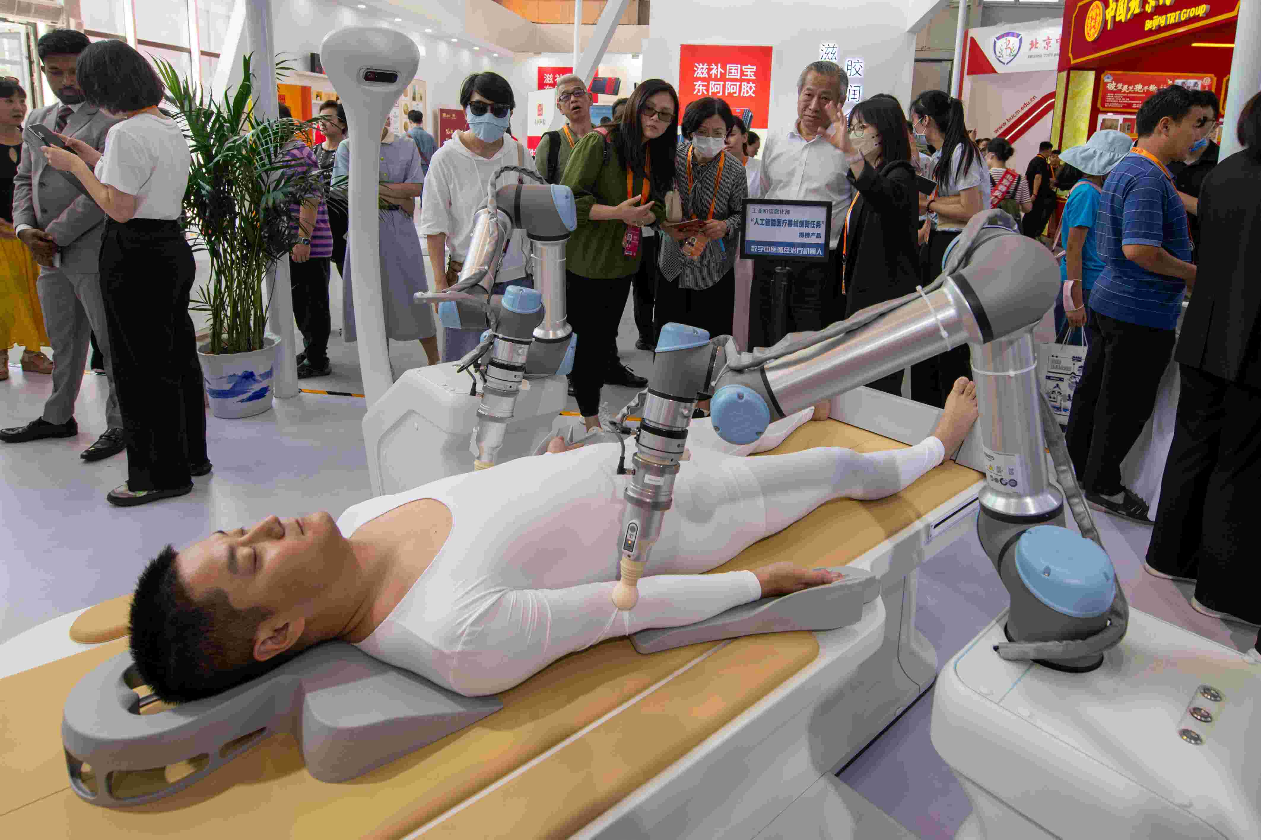 在位于首鋼園的健康衛(wèi)生服務(wù)展區(qū)，觀(guān)眾正在參觀(guān)數(shù)字中醫(yī)循經(jīng)治療機(jī)器人。人民網(wǎng)記者 翁奇羽攝