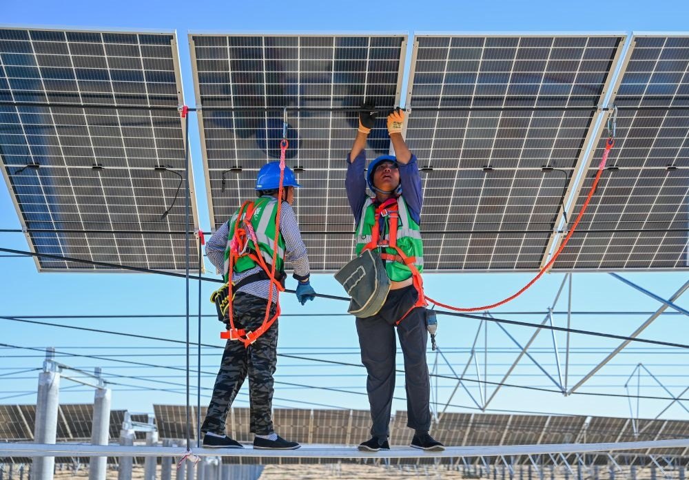 2023年7月22日，工人在位于內(nèi)蒙古杭錦旗庫布其沙漠億利生態(tài)示范區(qū)的蒙西基地庫布其200萬千瓦光伏治沙項目工地安裝光伏板。新華社記者 劉磊 攝
