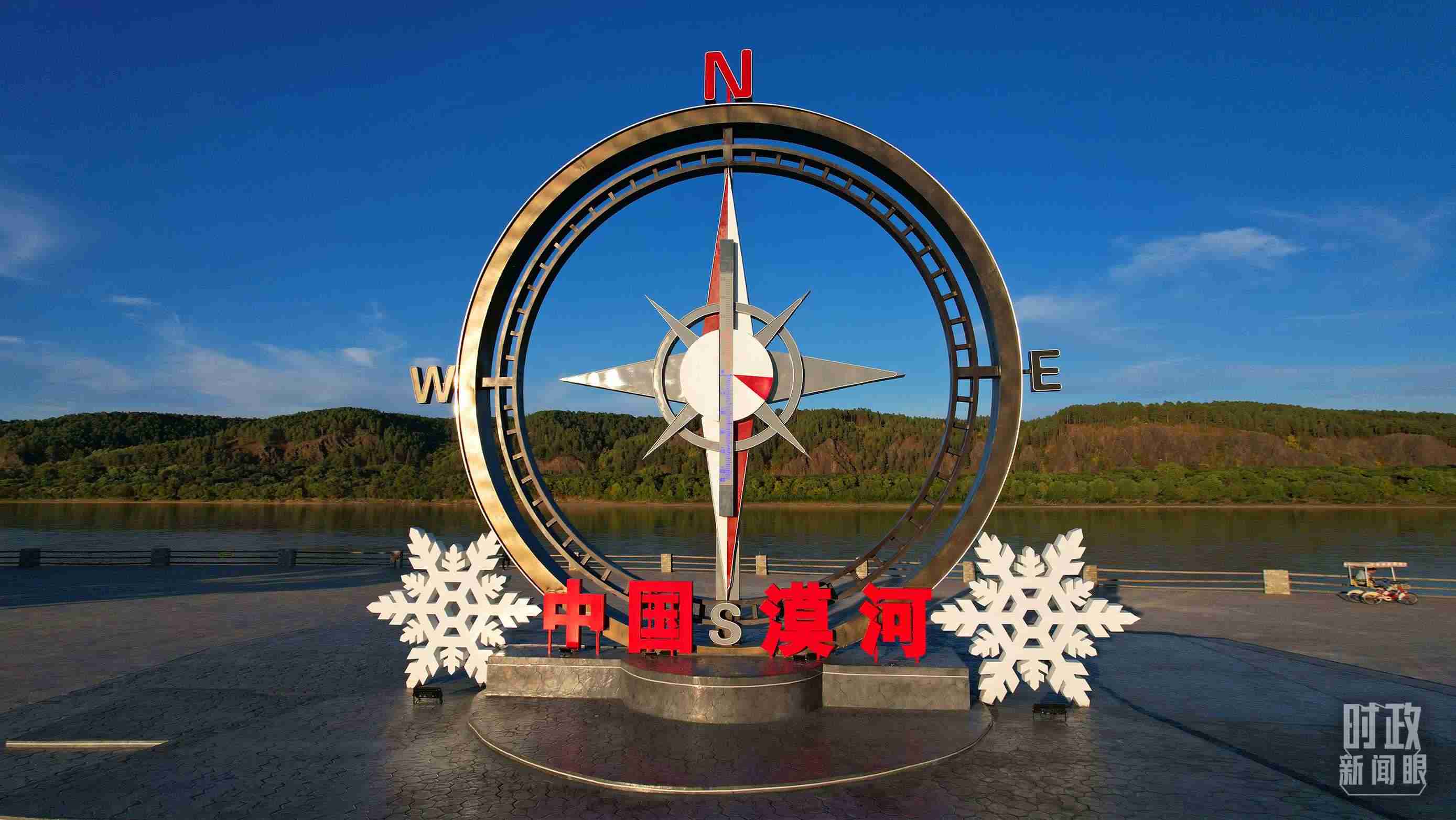 △指北針雕塑是北極村標志性建筑之一，其紅色指針指向正北方。上面的大型溫度計高12.22米，象征北極村位于東經(jīng)122°20′。（總臺央視記者范凱拍攝）