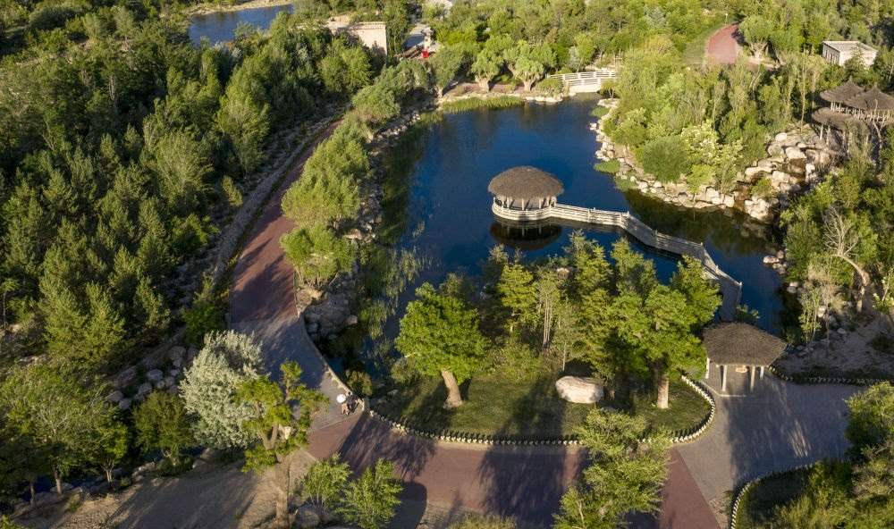 坐落在寧夏銀川市賀蘭山腳下的賀蘭山運動休閑公園（2021年5月27日攝，無人機照片）。這里曾是一片砂石采礦塌陷區(qū)，當?shù)赝ㄟ^植被景觀再造、水系建設(shè)、現(xiàn)代管網(wǎng)鋪建等手段，重新利用廢石、廢坑及各類廢棄建筑材料，把這里變成一座免費開放的主題公園。新華社記者 馮開華 攝