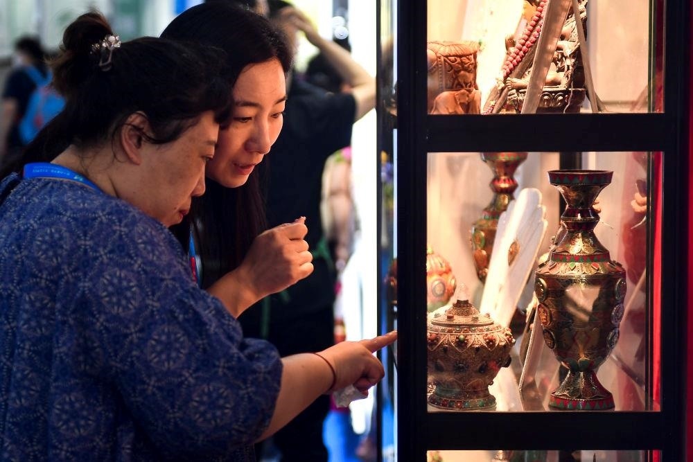 △2023年8月24日，參觀者在第十四屆中國—東北亞博覽會現(xiàn)場選購尼泊爾特色商品。