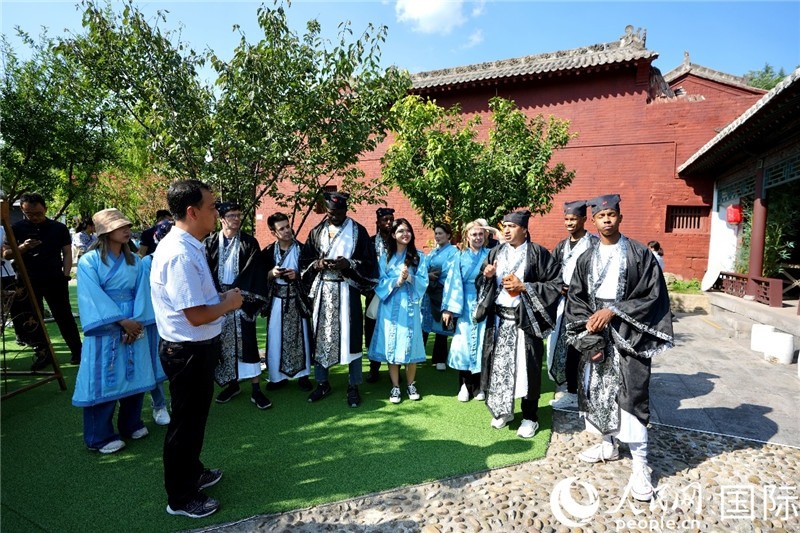 圖為選手們聽導游講解。人民網(wǎng) 盧鵬宇攝