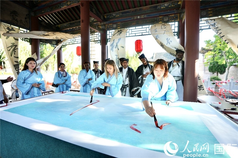 選手們提筆書寫“家園”二字。人民網(wǎng) 盧鵬宇攝