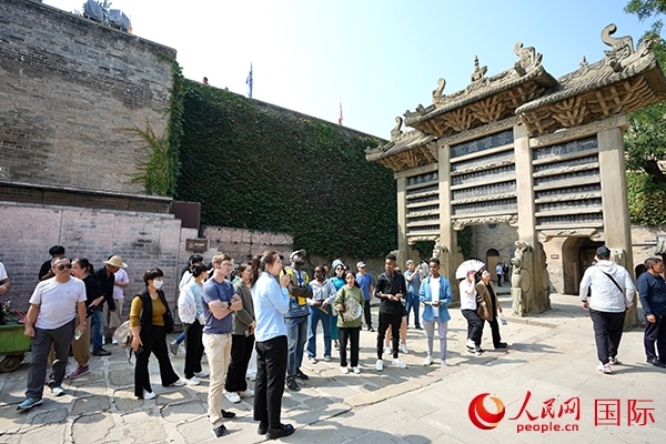 選手們認真聆聽導(dǎo)游講解。人民網(wǎng) 盧鵬宇攝