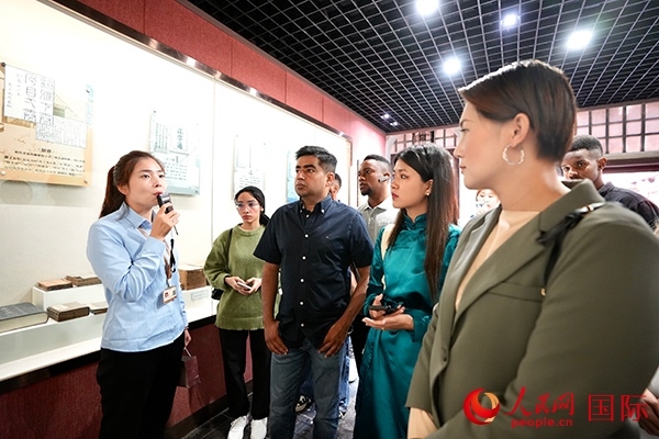 選手們認真聆聽導(dǎo)游講解。人民網(wǎng) 盧鵬宇攝