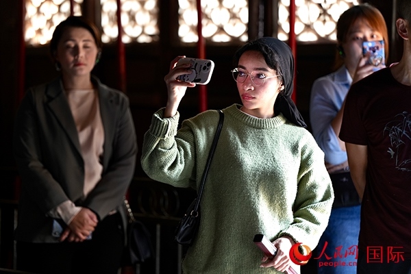 選手顏青（蘇丹）用手機記錄所見所感。人民網(wǎng) 盧鵬宇攝