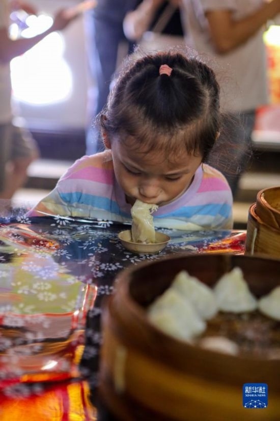 9月27日，小朋友在南翔小籠長街宴上品嘗南翔小籠。