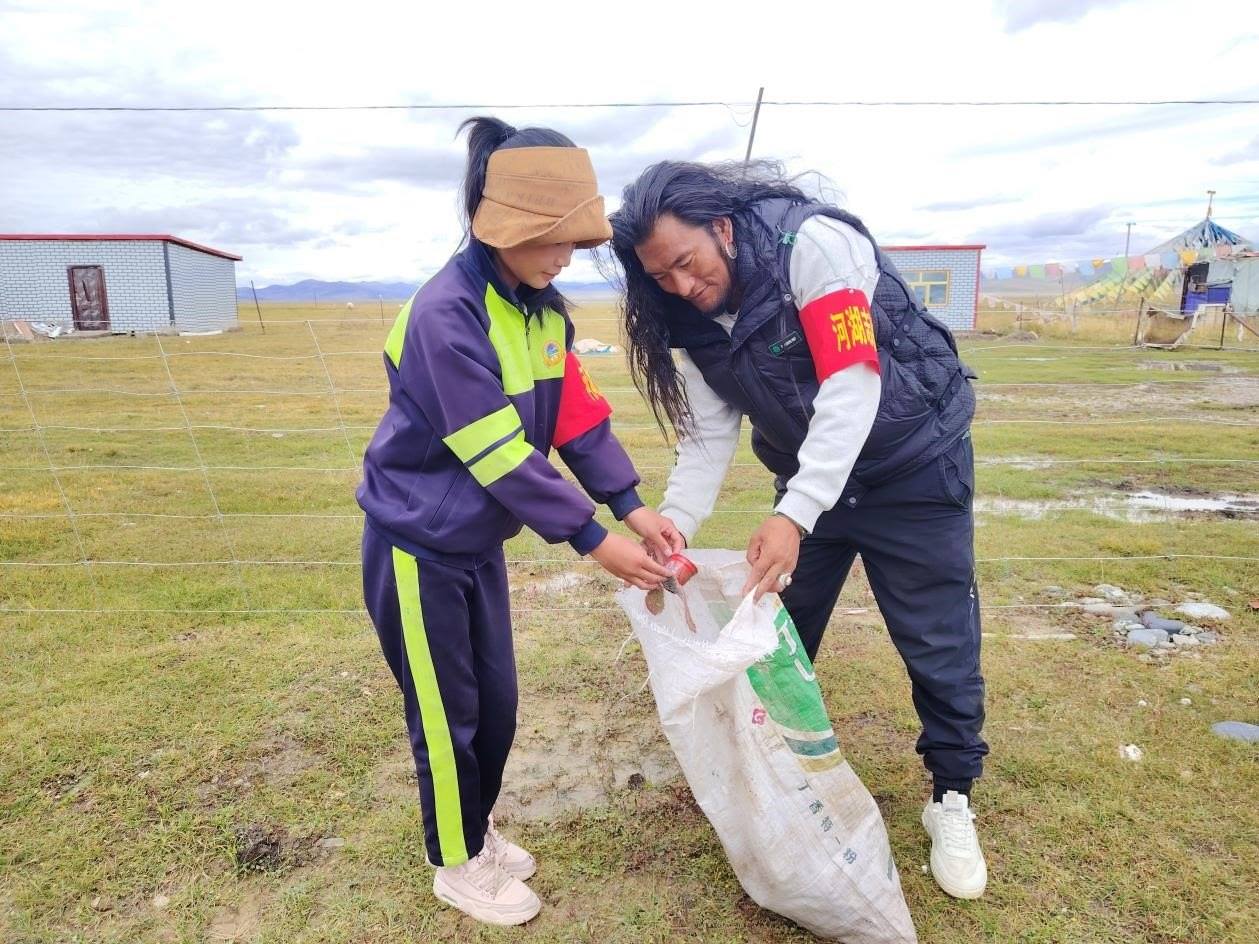 玉樹州稱多縣珍秦鎮(zhèn)河湖志愿者才培和他女兒更求拉毛在清掃垃圾。受訪者供圖