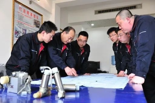 △李志強(qiáng)（左二）與班組成員在研究工作。