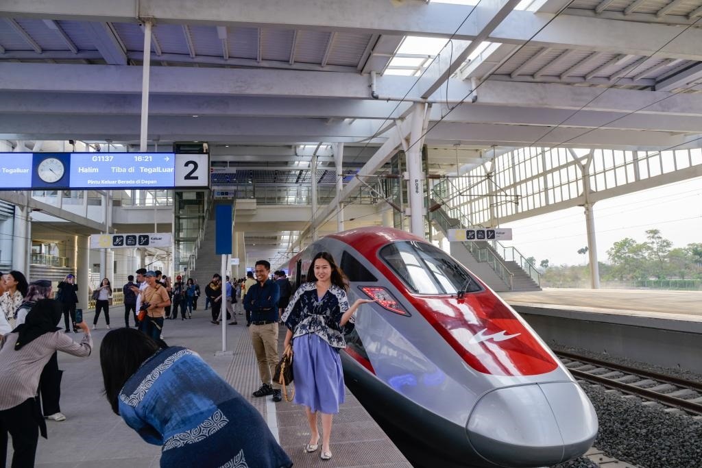 10月17日，在印度尼西亞萬隆德卡魯爾站，乘客在站臺(tái)上和雅萬高鐵高速動(dòng)車組列車合影。