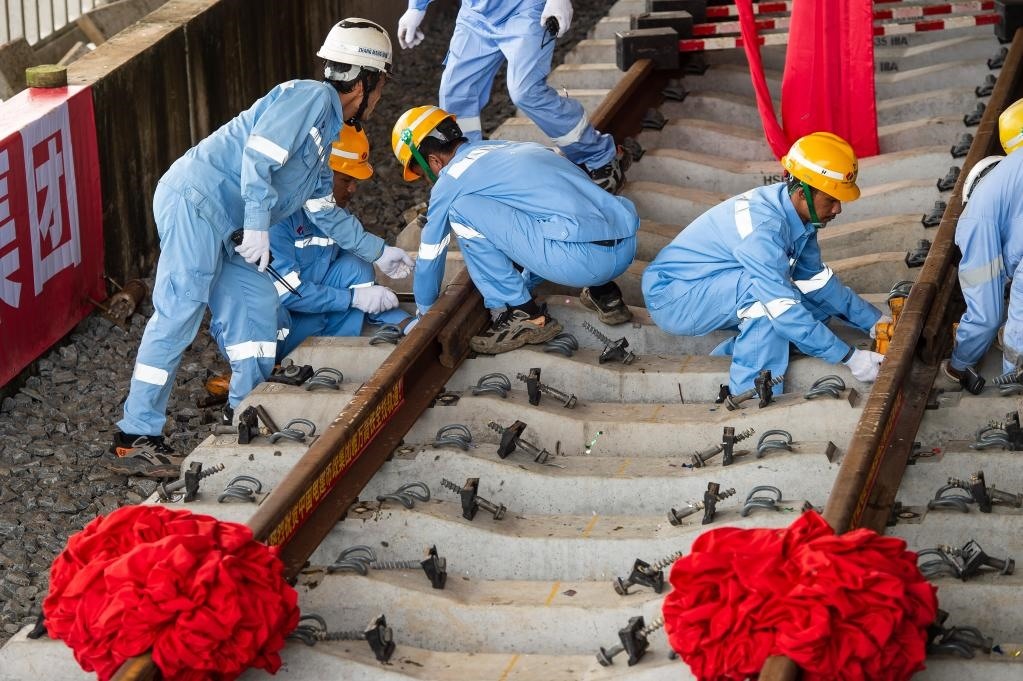 3月31日，在印度尼西亞雅加達(dá)雅萬高鐵哈利姆車站，工人鋪設(shè)雅萬高鐵全線最后一根鋼軌。