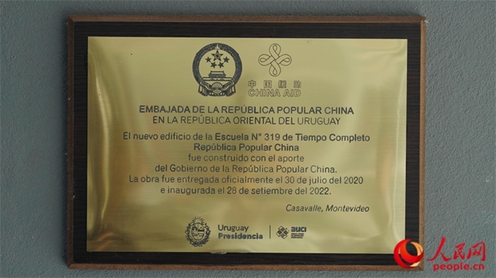 小學墻上懸掛的中國援助標識。人民網(wǎng)記者 張若涵攝