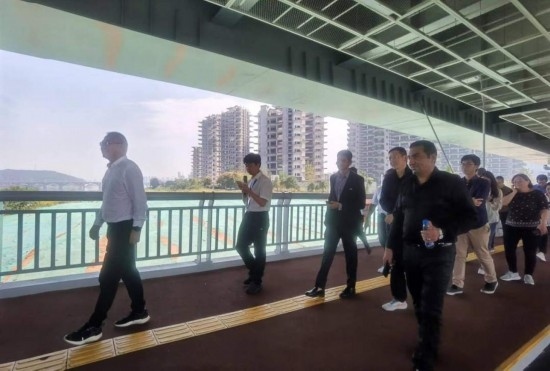 10月24日，2023“一帶一路”媒體合作論壇聯(lián)合采訪團(tuán)團(tuán)員走在清水塘大橋景觀通道上。本報(bào)記者 常雯宜攝