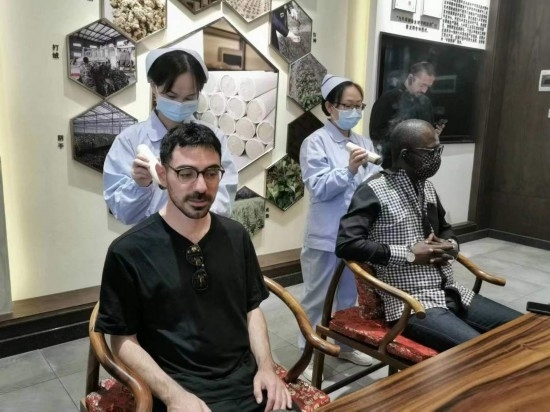 2023“一帶一路”媒體合作論壇聯(lián)合采訪團(tuán)團(tuán)員在九牛草展示館體驗(yàn)艾灸。（本報(bào)記者 黃超攝）