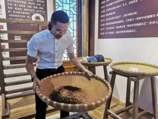 2023“一帶一路”媒體合作論壇聯(lián)合采訪團(tuán)團(tuán)員在非遺文化展示館體驗(yàn)中藥炮制技藝。（本報(bào)記者 黃超攝）