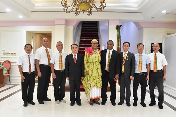 多米尼克總統(tǒng)伯頓和駐多米尼克大使林先江與中國(guó)農(nóng)業(yè)技術(shù)專家組合影。中國(guó)駐多米尼克大使館供圖