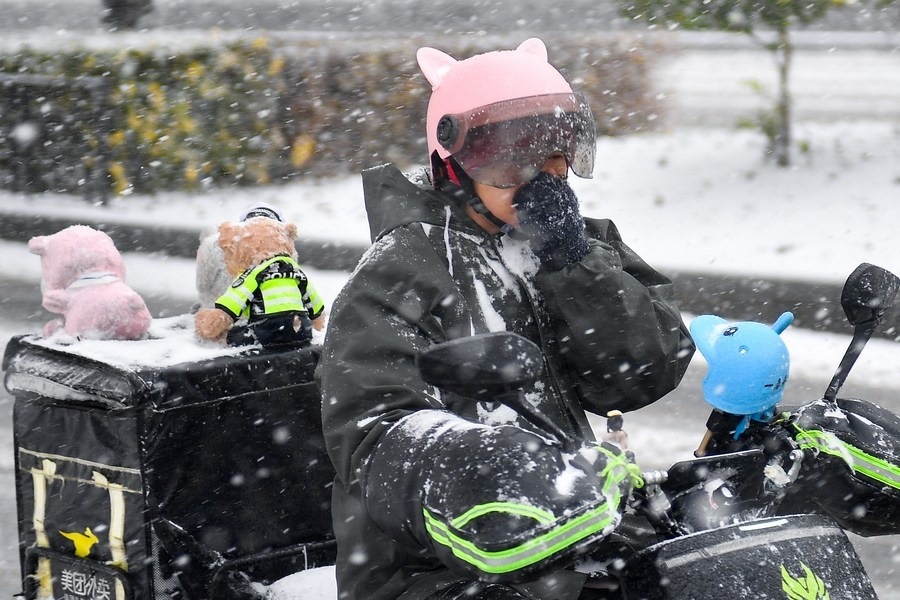 11月6日，在長春市街頭，一名外賣員在雪中騎行。新華社記者 許暢 攝