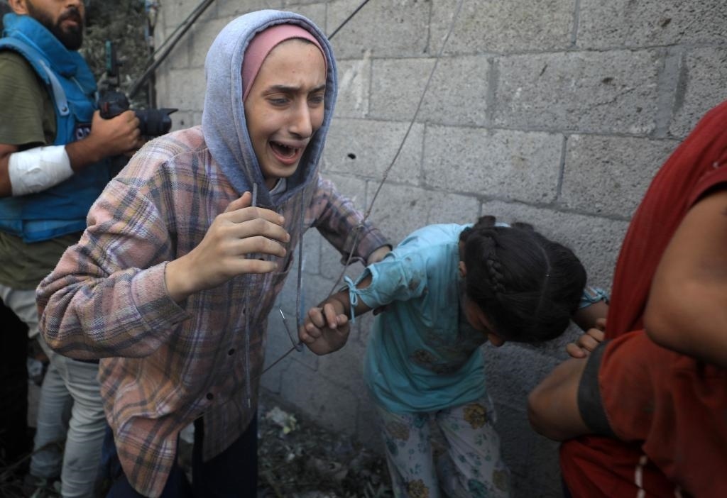 11月6日，人們從加沙地帶中部地區(qū)一處被炸難民營逃離。新華社發(fā)（亞西爾·庫迪攝）